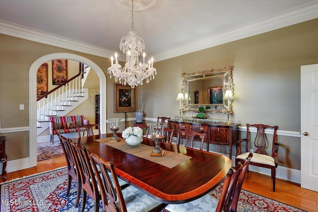 607 Tiffintown Rd, Vicksburg, MS 39183 - dining room featuring crown molding, wood finished floors, stairs, arched walkways, and an inviting chandelier