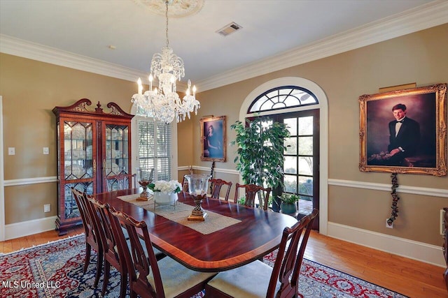 607 Tiffintown Rd, Vicksburg, MS 39183 - dining area with wood-type flooring, an inviting chandelier, ornamental molding, and visible vents
