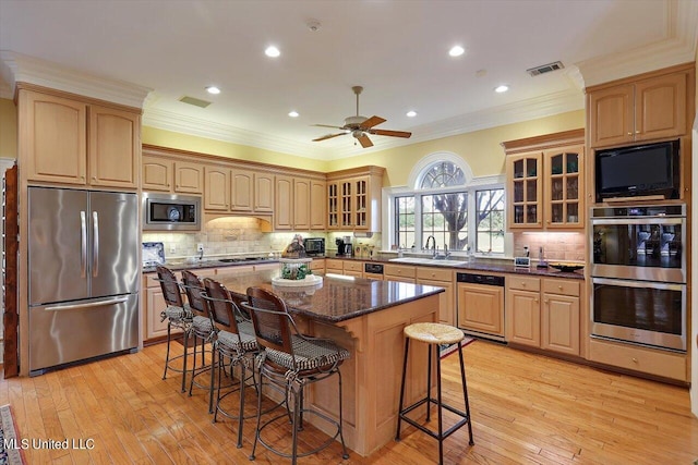 607 Tiffintown Rd, Vicksburg, MS 39183 - kitchen featuring a sink, a breakfast bar area, appliances with stainless steel finishes, ornamental molding, and visible vents