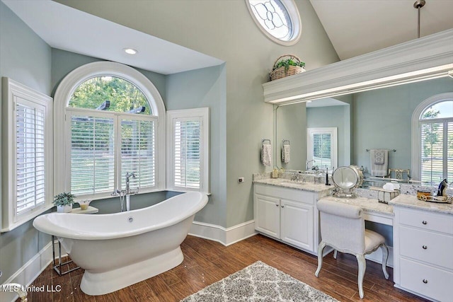 607 Tiffintown Rd, Vicksburg, MS 39183 - full bath featuring vaulted ceiling, baseboards, a freestanding tub, wood finished floors, and vanity