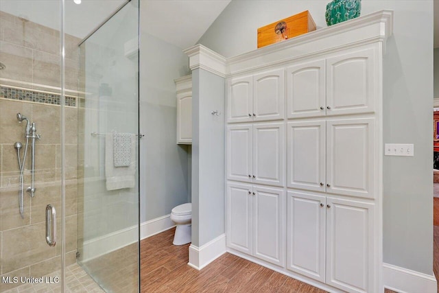 607 Tiffintown Rd, Vicksburg, MS 39183 - bathroom featuring toilet, wood finished floors, baseboards, and a stall shower