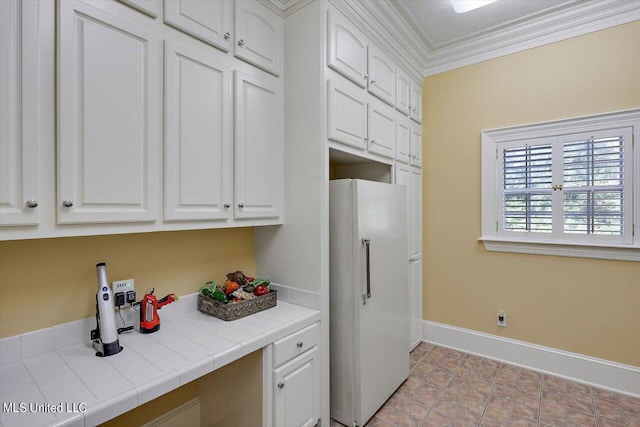 607 Tiffintown Rd, Vicksburg, MS 39183 - kitchen featuring tile countertops, baseboards, white cabinetry, and freestanding refrigerator