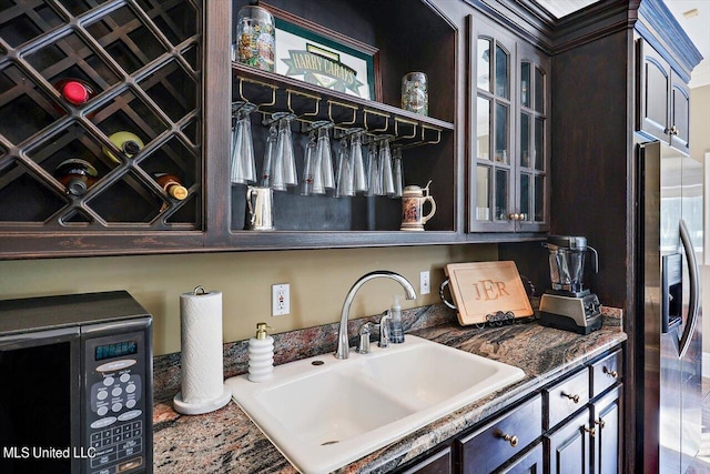 607 Tiffintown Rd, Vicksburg, MS 39183 - interior details with dark brown cabinets, glass insert cabinets, a sink, and stainless steel fridge