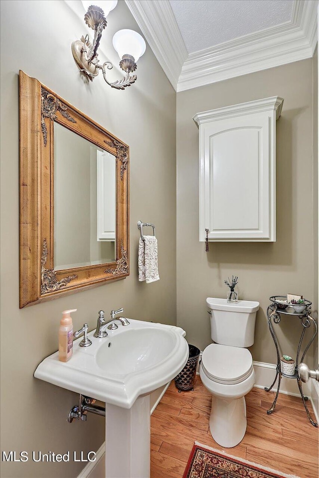607 Tiffintown Rd, Vicksburg, MS 39183 - half bath featuring wood finished floors, ornamental molding, baseboards, toilet, and a notable chandelier