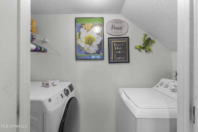 clothes washing area featuring washer and dryer and a textured ceiling