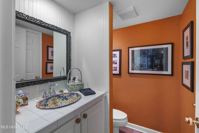 bathroom featuring vanity and toilet