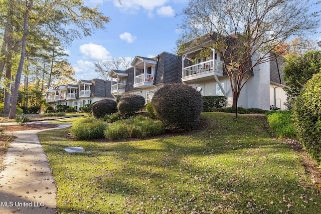 exterior space with a balcony and a yard