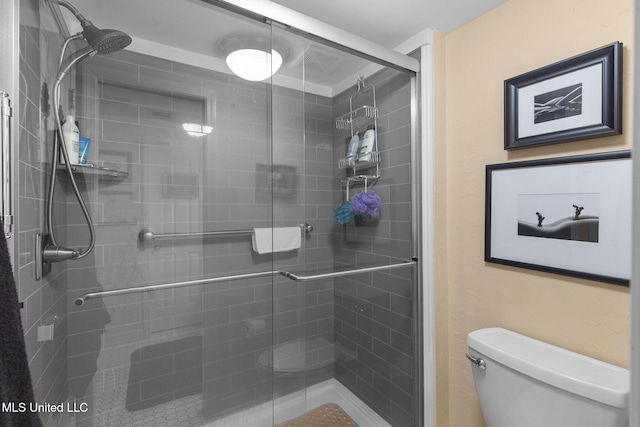 bathroom with toilet and an enclosed shower