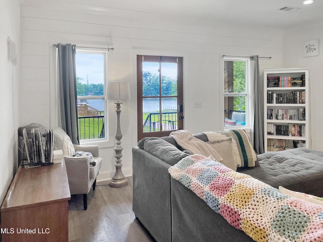 living room featuring a water view and light hardwood / wood-style flooring