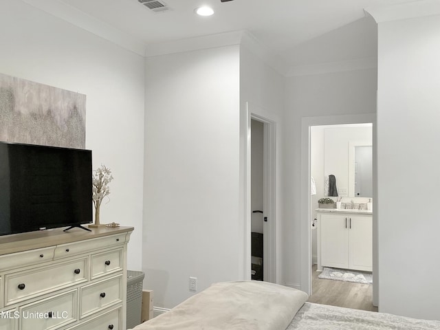 bedroom featuring crown molding, connected bathroom, sink, and light wood-type flooring