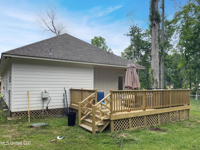 rear view of house with a wooden deck and a yard