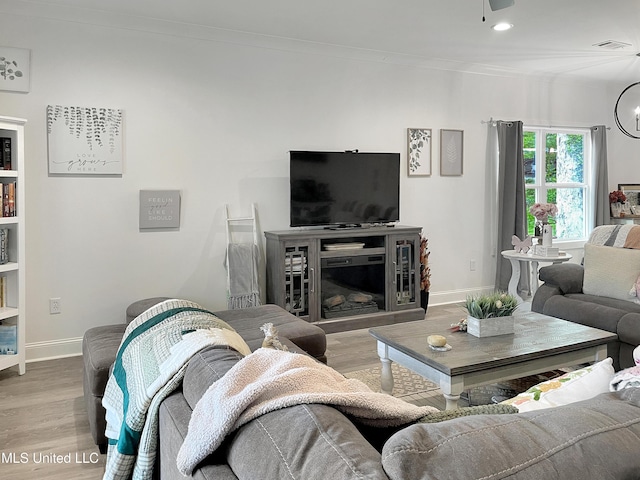 living room featuring hardwood / wood-style flooring and ornamental molding