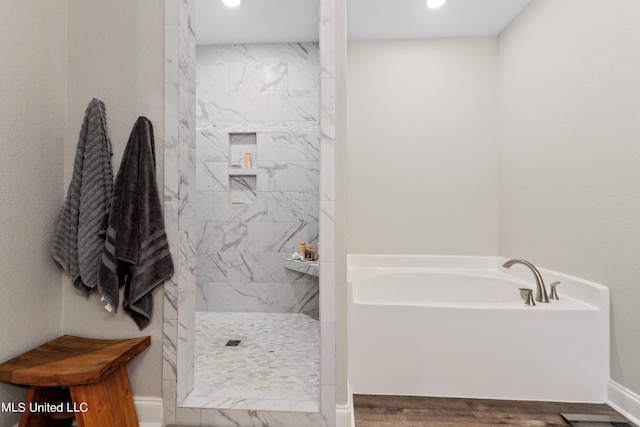 bathroom with hardwood / wood-style flooring and independent shower and bath