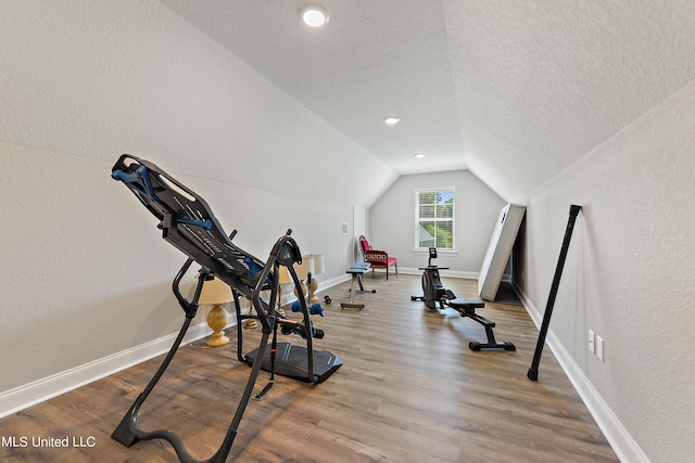 workout area with lofted ceiling, a textured ceiling, and hardwood / wood-style flooring