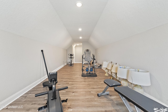 exercise area with lofted ceiling and light hardwood / wood-style flooring