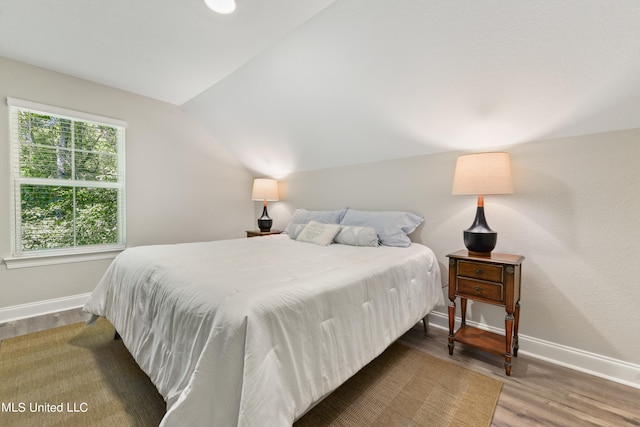 bedroom featuring vaulted ceiling and dark hardwood / wood-style flooring