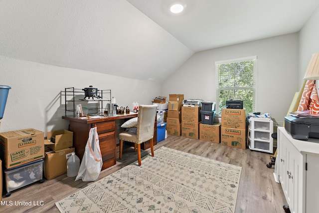 office space with light hardwood / wood-style floors and lofted ceiling