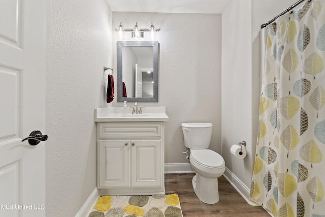 bathroom featuring vanity, hardwood / wood-style floors, toilet, and walk in shower