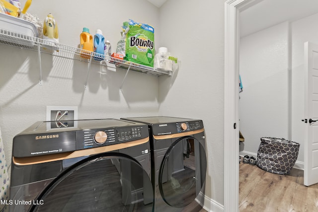 clothes washing area featuring independent washer and dryer and hardwood / wood-style floors