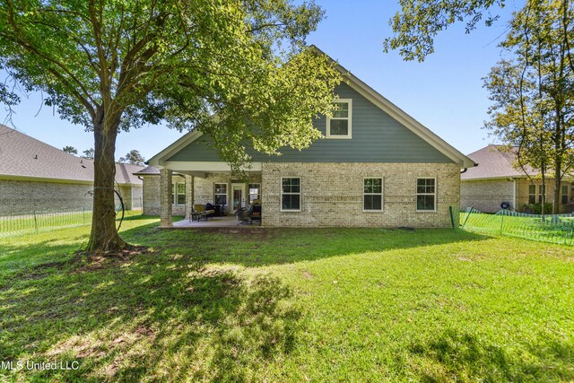 rear view of house with a patio area and a lawn