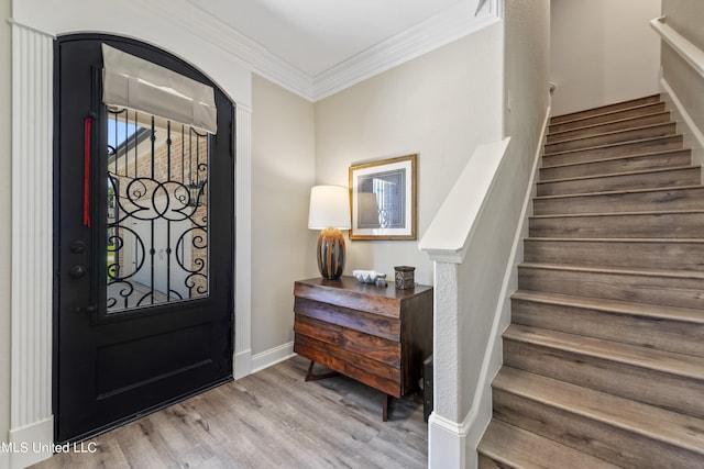 foyer with light hardwood / wood-style floors and ornamental molding