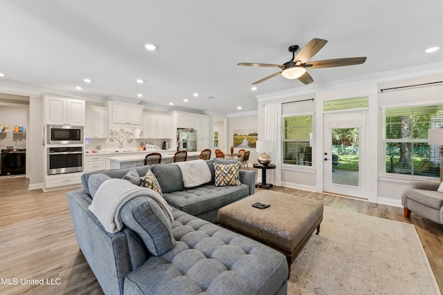 living room with crown molding, light hardwood / wood-style flooring, and ceiling fan