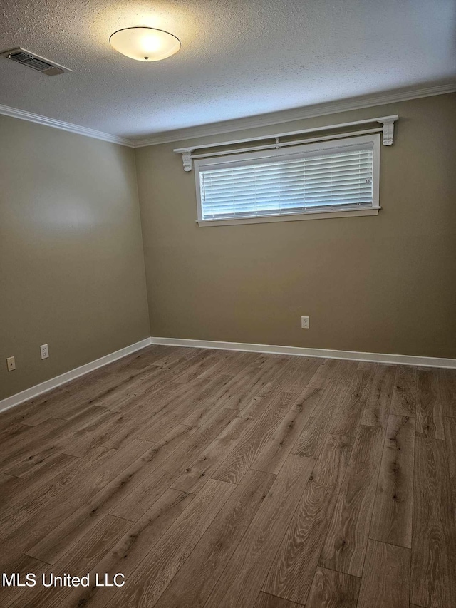 unfurnished room with wood-type flooring, crown molding, and a textured ceiling