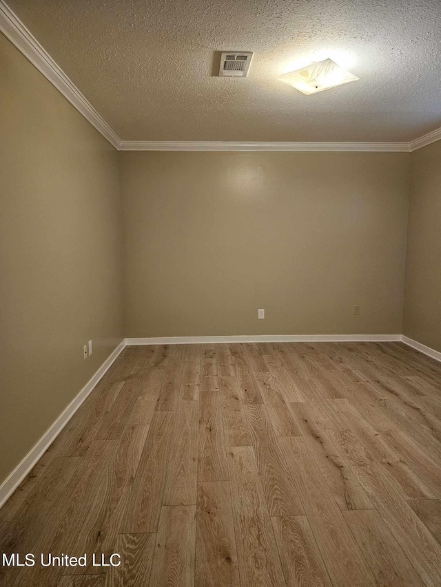 spare room featuring ornamental molding, a textured ceiling, and light hardwood / wood-style flooring