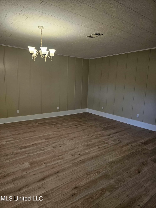 unfurnished room featuring dark hardwood / wood-style floors and an inviting chandelier