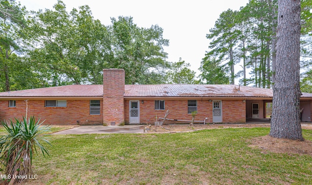 back of house featuring a lawn and a patio area