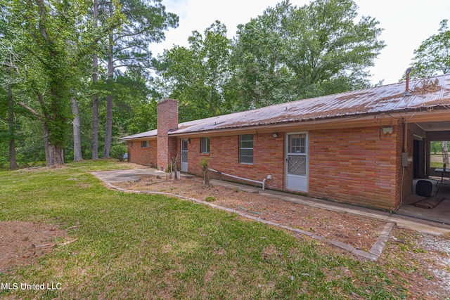 back of house with a patio area and a lawn