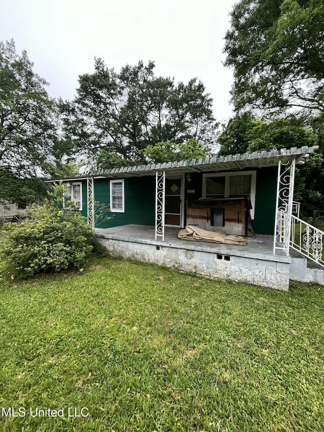 rear view of property with a lawn
