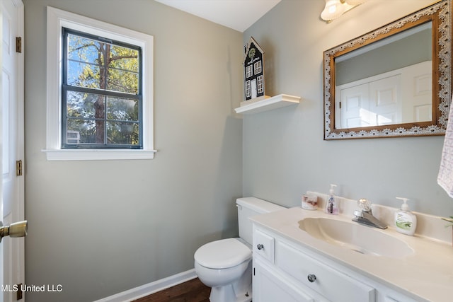 bathroom with hardwood / wood-style floors, vanity, and toilet