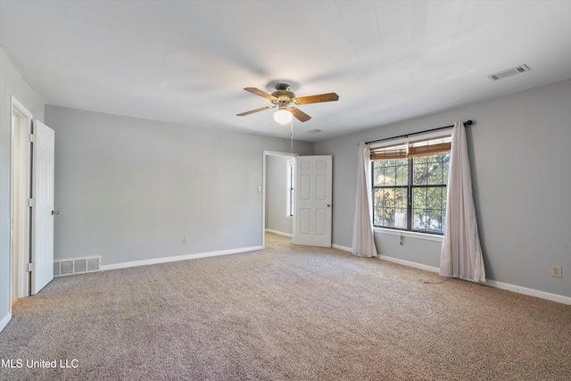 carpeted spare room featuring ceiling fan