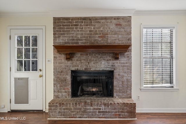 interior details featuring hardwood / wood-style floors, ornamental molding, and a brick fireplace