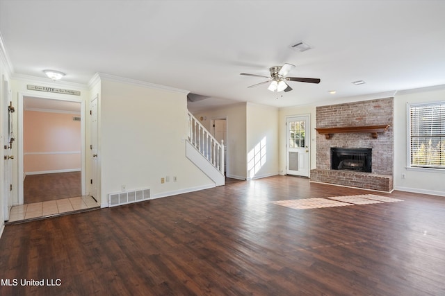 unfurnished living room featuring ceiling fan, wood-type flooring, a fireplace, and ornamental molding