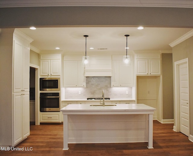 kitchen featuring pendant lighting, dark hardwood / wood-style floors, an island with sink, and appliances with stainless steel finishes