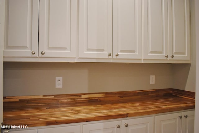 kitchen featuring white cabinetry and butcher block counters