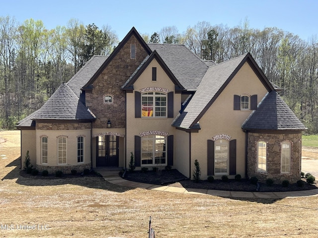 145 Poplar Ln, Holly Springs, MS 38635 - french country style house with french doors, stone siding, roof with shingles, and brick siding