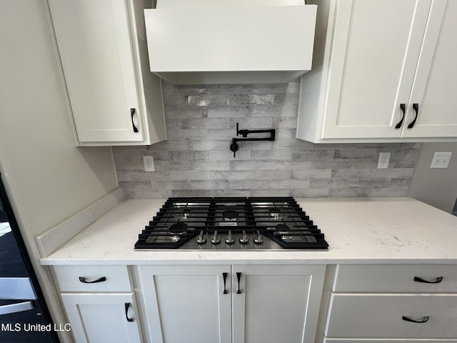 145 Poplar Ln, Holly Springs, MS 38635 - kitchen featuring stainless steel gas stovetop, decorative backsplash, white cabinetry, and light stone countertops