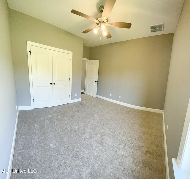 unfurnished bedroom with ceiling fan, carpet floors, and a closet