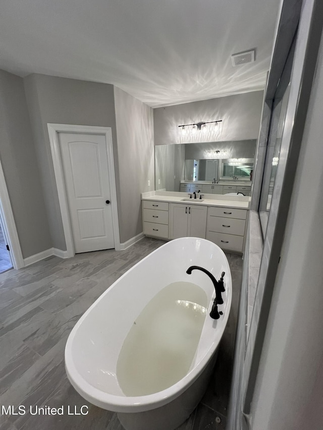 145 Poplar Ln, Holly Springs, MS 38635 - bathroom featuring a freestanding tub, vanity, track lighting, and baseboards