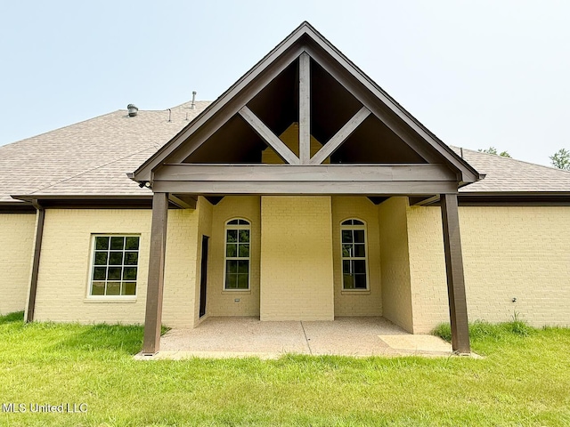 145 Poplar Ln, Holly Springs, MS 38635 - back of property with a patio area, a lawn, and roof with shingles