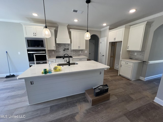 145 Poplar Ln, Holly Springs, MS 38635 - kitchen with oven, custom range hood, arched walkways, a sink, and stainless steel microwave