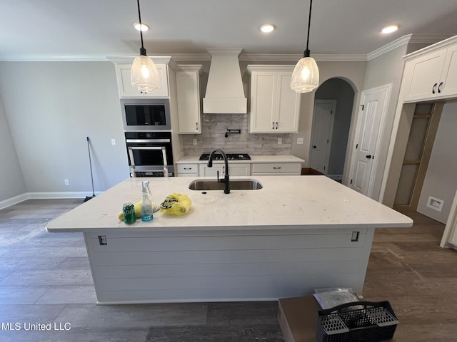 145 Poplar Ln, Holly Springs, MS 38635 - kitchen with appliances with stainless steel finishes, wall chimney exhaust hood, a sink, white cabinetry, and baseboards