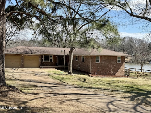 view of front of property featuring a garage, dirt driveway, fence, and brick siding