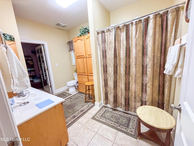 8855 Pine Springs Rd, Meridian, MS 39305 - bathroom featuring toilet, tile patterned flooring, vanity, and curtained shower