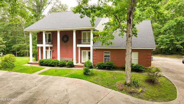 8855 Pine Springs Rd, Meridian, MS 39305 - greek revival house with a balcony, brick siding, roof with shingles, and a front yard
