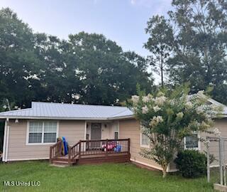 1124 Old Mobile Hwy, Lucedale, MS 39452 - rear view of house with a yard, a deck, and a metal roof