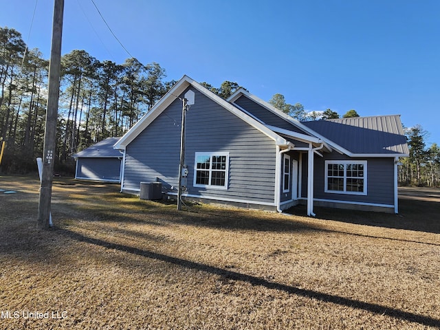 view of front facade with a front lawn and central air condition unit